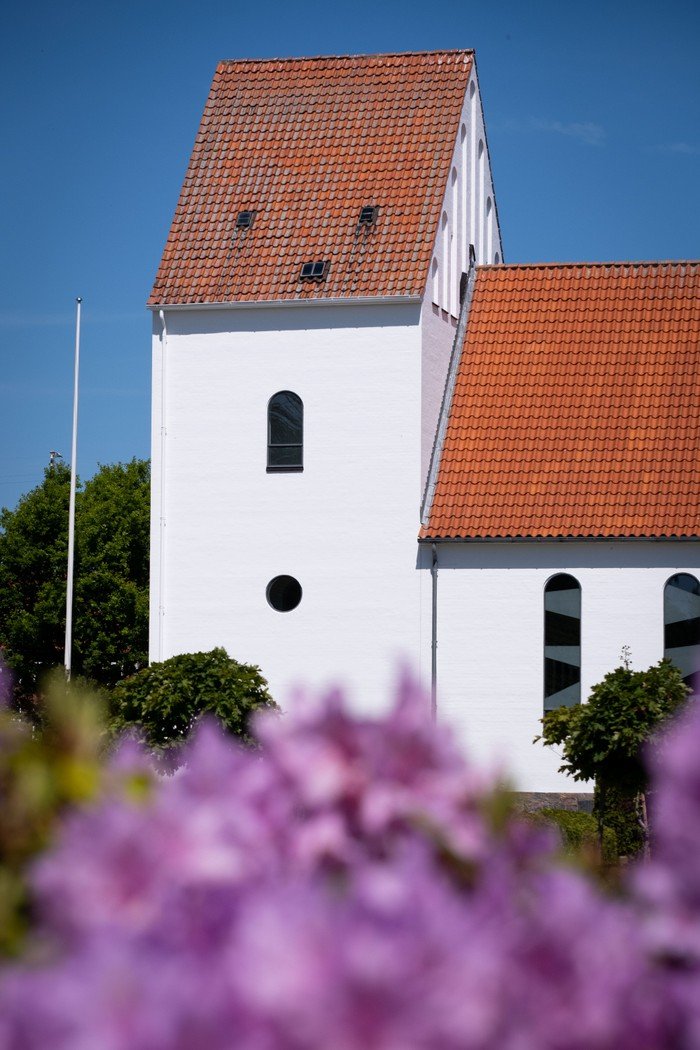 Ansgarkirken taget op mod indgangen med store træer i forgrunden.